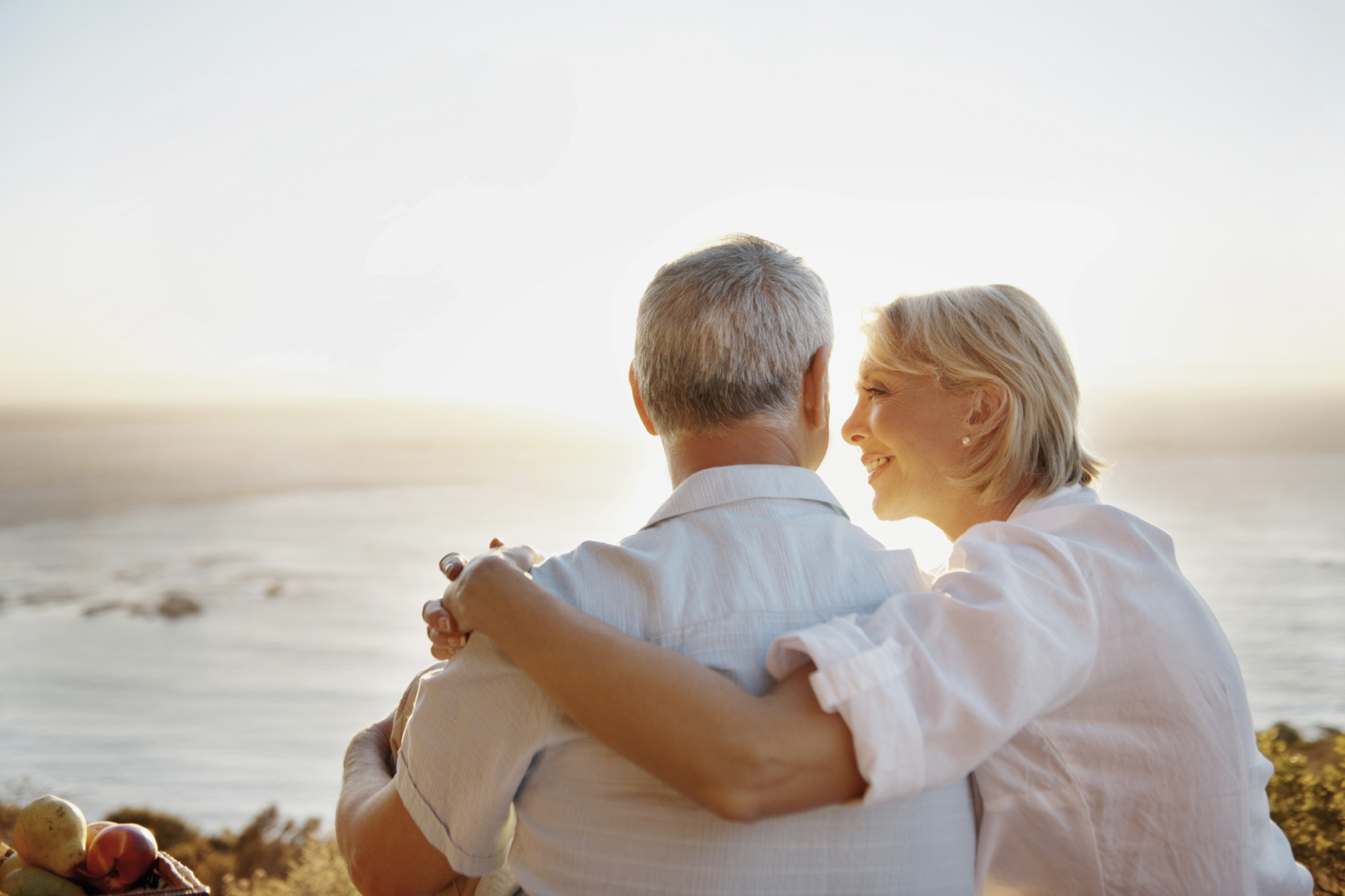 A loving senior couple looking into one another's eyes against a beautiful sunset - Copyspace